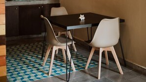 Une cuisine de taille réduite équipée d’un four à micro-ondes, d’une table à manger avec des chaises et d’un sol à motifs.