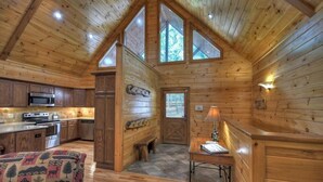 L’intérieur d’une cabane en rondins comprend une cuisine, un coin repas et un espace salon confortable.