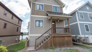 A two-story residential building with a balcony and wooden staircase. - Swim, Ski & Scenic Lake Views by Deep Creek Lake (MCHENRY)