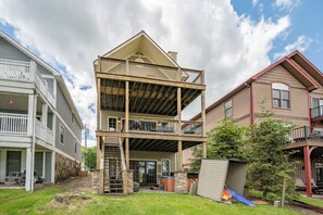 A two-story building with a balcony, a stone staircase, and a small shed.