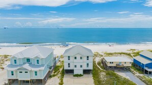 A beachfront property with multiple houses, a sandy beach, and the ocean in the background.