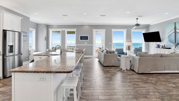 A spacious kitchen with a granite countertop, white cabinetry, and a large island.