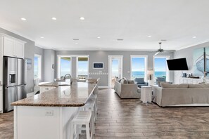 A spacious kitchen with a granite countertop, white cabinetry, and a large island.