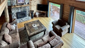 A spacious wooden cabin with a stone fireplace, a television, and comfortable seating. - Theater Room,Pool Table,Foosball,HotTub,WiFi,Views (Ferguson)