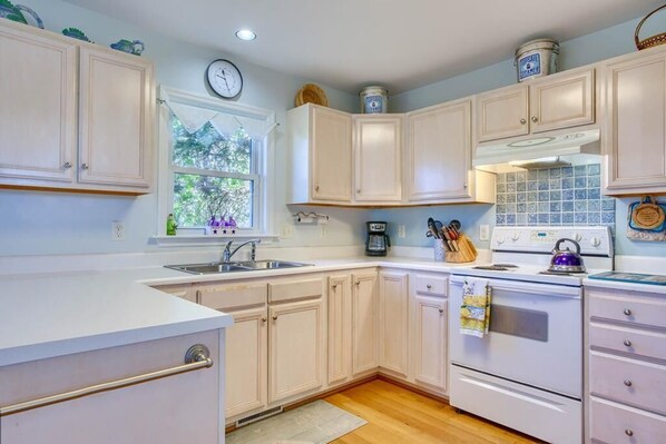 Kitchen features a stove, oven, and coffee maker on the central island.