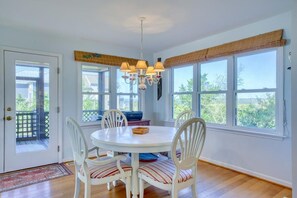 Enjoy meals in this dining area with a round table and four chairs, surrounded by a view of lush greenery.