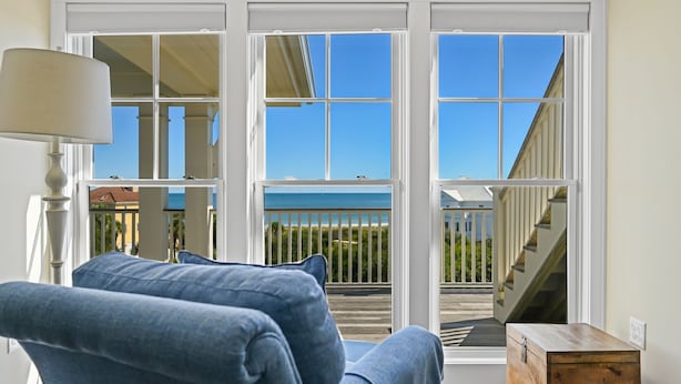 Une chambre avec vue sur un balcon et une commode en bois.