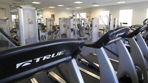 A gym with treadmills, weight machines, and mirrors. - Spacious One Bedroom with Pool View! (Bonita Springs)