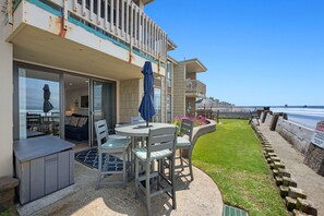 A seaside property with a balcony, outdoor seating, and a view of the ocean. - The closest condo to the ocean! New bathrooms, carpet, and furniture! Panoramic ocean views D17 (Oceanside)