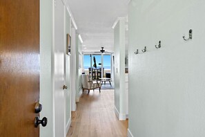 A hallway leading to a dining area with a view of the beach. - The closest condo to the ocean! New bathrooms, carpet, and furniture! Panoramic ocean views D17 (Oceanside)