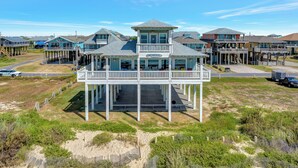 Une propriété située en bord de mer, avec un bâtiment principal doté d’un balcon et d’une enseigne indiquant : « The Good Stuff ».
