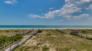 Une plage avec des passerelles en bois et un kiosque.