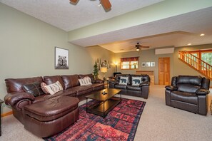 A living room with a brown leather sofa, a matching armchair, and a coffee table.