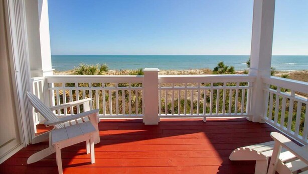 A covered porch with a view of the beach, white railings, and two white Adirondack chairs. - Sandstep 616-2 (Carolina Beach)