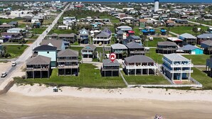 An aerial view of a coastal residential area with houses, a beach, and a marked location. - Aloha Cabana: 2  BR, 1  BA House in Crystal Beach, Sleeps 8 (Crystal Beach)