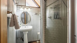 A bathroom with a pedestal sink, a mirror, and a shower area. - Chalet #5, Ski In Ski Out Chalet at the Main Lodge (Mammoth Lakes)