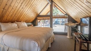 A cozy attic bedroom with a large bed, a sink, and a view of the outside. - Chalet #5, Ski In Ski Out Chalet at the Main Lodge (Mammoth Lakes)