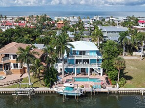 A large house with a pool, dock, and waterfront view.