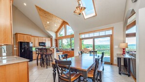 A spacious kitchen with wooden cabinets, a large island, and a dining area with a wooden table and chairs.
