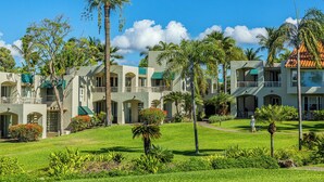 A resort with multiple buildings, palm trees, and well-maintained lawns.