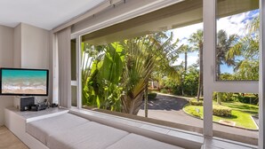 A modern room with a large window, a flat-screen TV, and a built-in seating area.