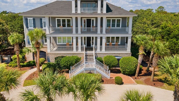 A two-story house with a balcony on each floor, surrounded by palm trees and a well-maintained garden. - Sprawling Home Close to the Beach (Georgetown)
