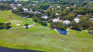 An aerial view of a residential area with houses, green lawns, and a golf course. - Relax in this 3BR Villa with Pool Overlooking the 1st Fairway. (Georgetown)