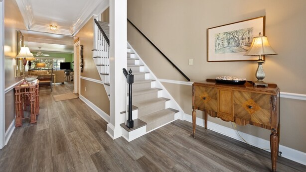 A staircase with white railings and a wooden console table with a lamp beside it. - Relax in this 3BR Villa with Pool Overlooking the 1st Fairway. (Georgetown)