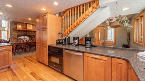 A kitchen with wooden cabinets, a dishwasher, a stove, and a coffee maker. - Dog Friendly Deep Creek Estate w/ Fire Pit & Dock (MCHENRY)
