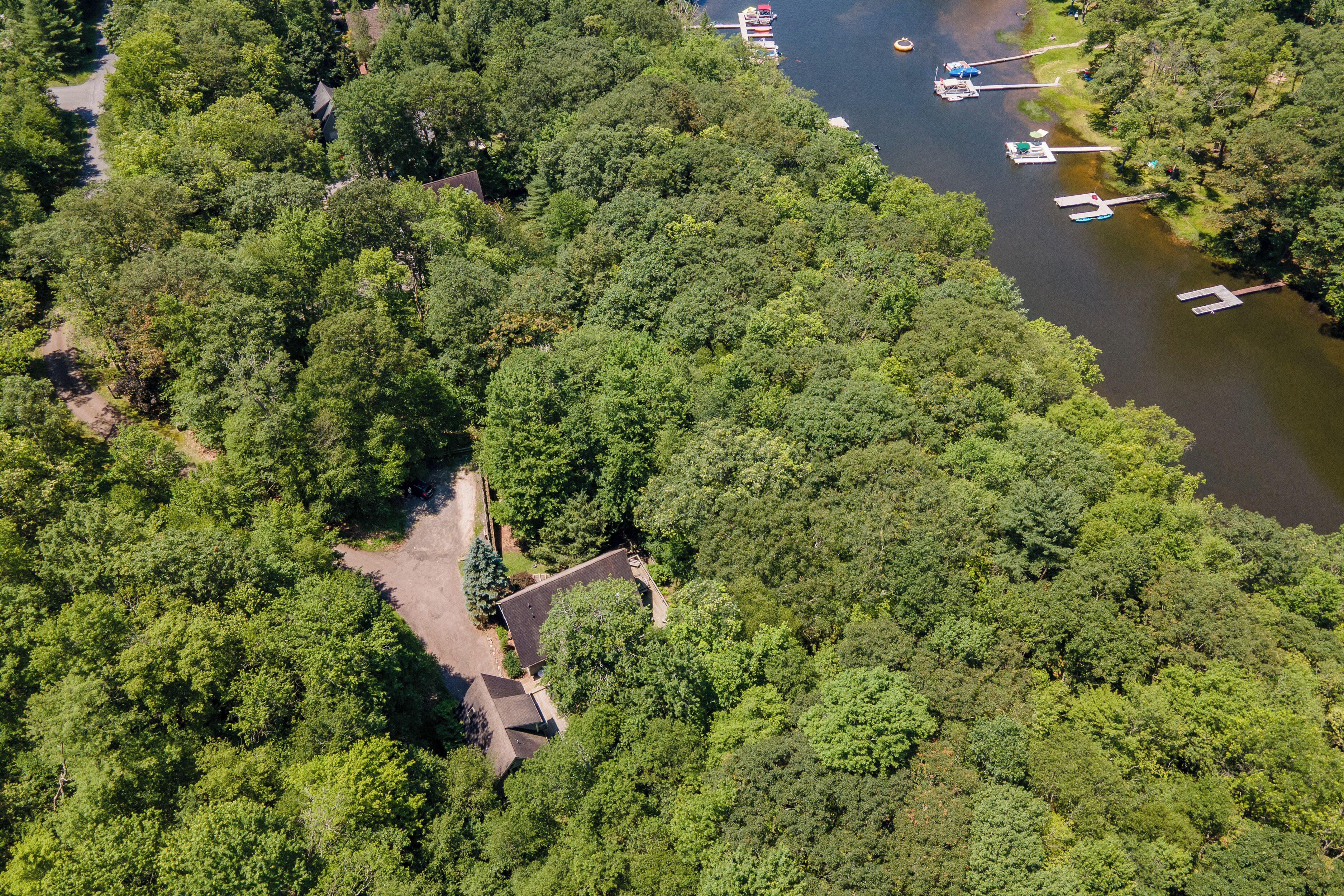 An aerial view of a forested area with a dock and boats.