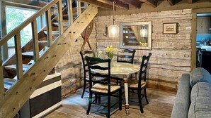 Un interior rústico de madera con comedor, escalera y una zona de estar acogedora.