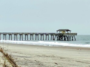A beach with a long pier extending into the ocean. - Oceanview Retreat, 302 (Tybee Island)