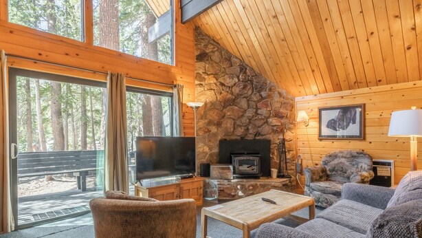 A cozy cabin interior with a stone fireplace, a television, and comfortable seating. - Chalet #25, Charming Ski in/ Ski Out, just steps to the Mountain (Mammoth Lakes)
