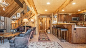 Un interior rústico con una escalera de madera, una zona de bar y un comedor.