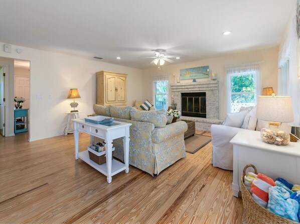 A spacious living room with a fireplace, a sofa, a coffee table, and a lamp. - Kingfish: *Canalfront *Paddleboards *Putt Putt *Heated Pool *Hot Tub (Anna Maria)