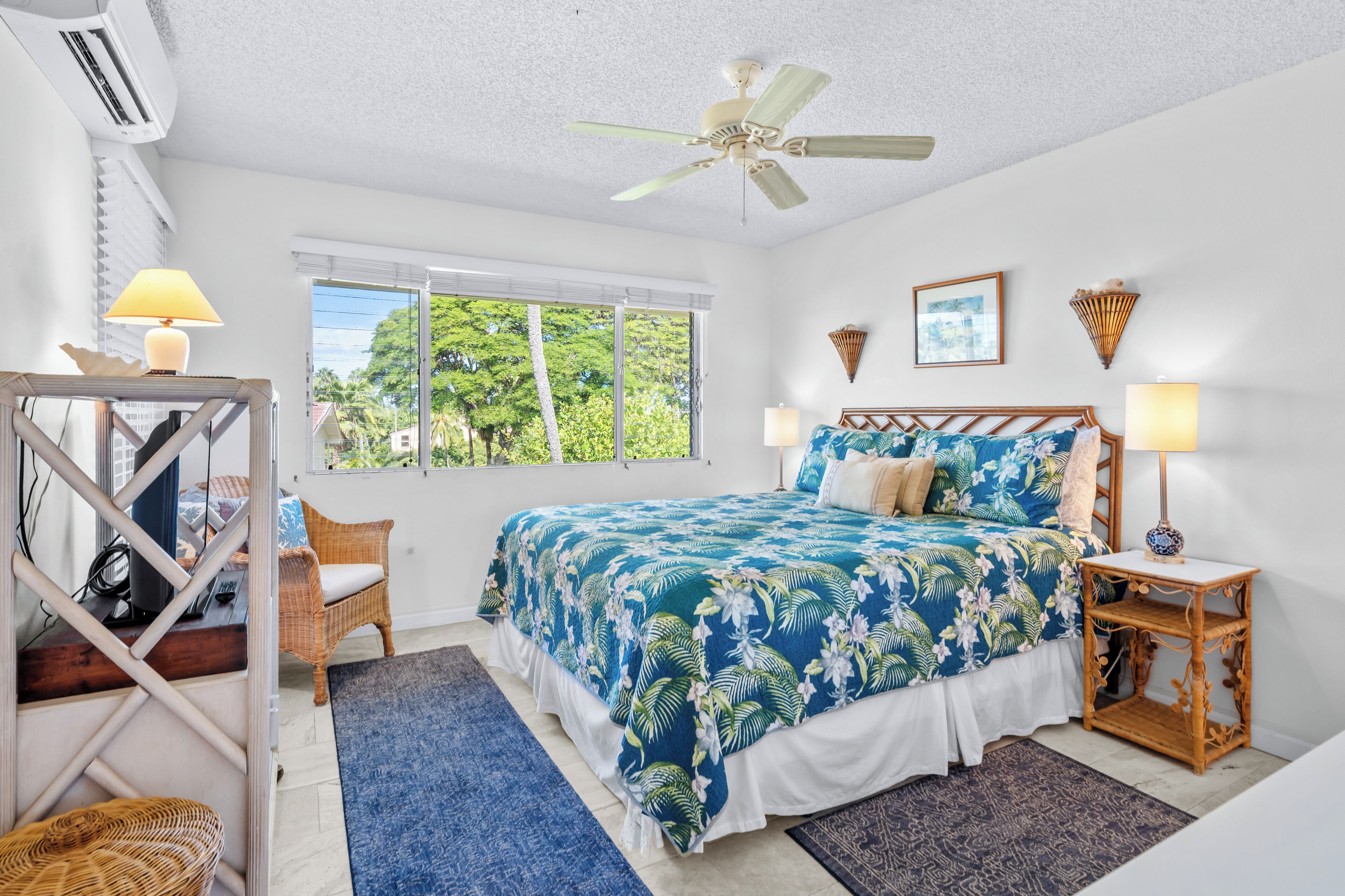 A bedroom with a bed, two bedside tables, a ceiling fan, a window, and a chair.