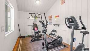Ett gym med träningsutrustning, en motionscykel och en träningsmatta.
