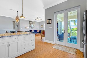 A kitchen with white cabinets, a marble countertop, and a ceiling fan. - P67 - Spacious 3 bedroom 4 bath with private pool, dock and beach membership! (Key Colony Beach)