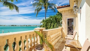 A balcony with a view of the sea, a potted plant, and outdoor furniture. - P05 - 5 bedroom Ocean Front home with Private pool and deep water dockage. (Key Colony Beach)