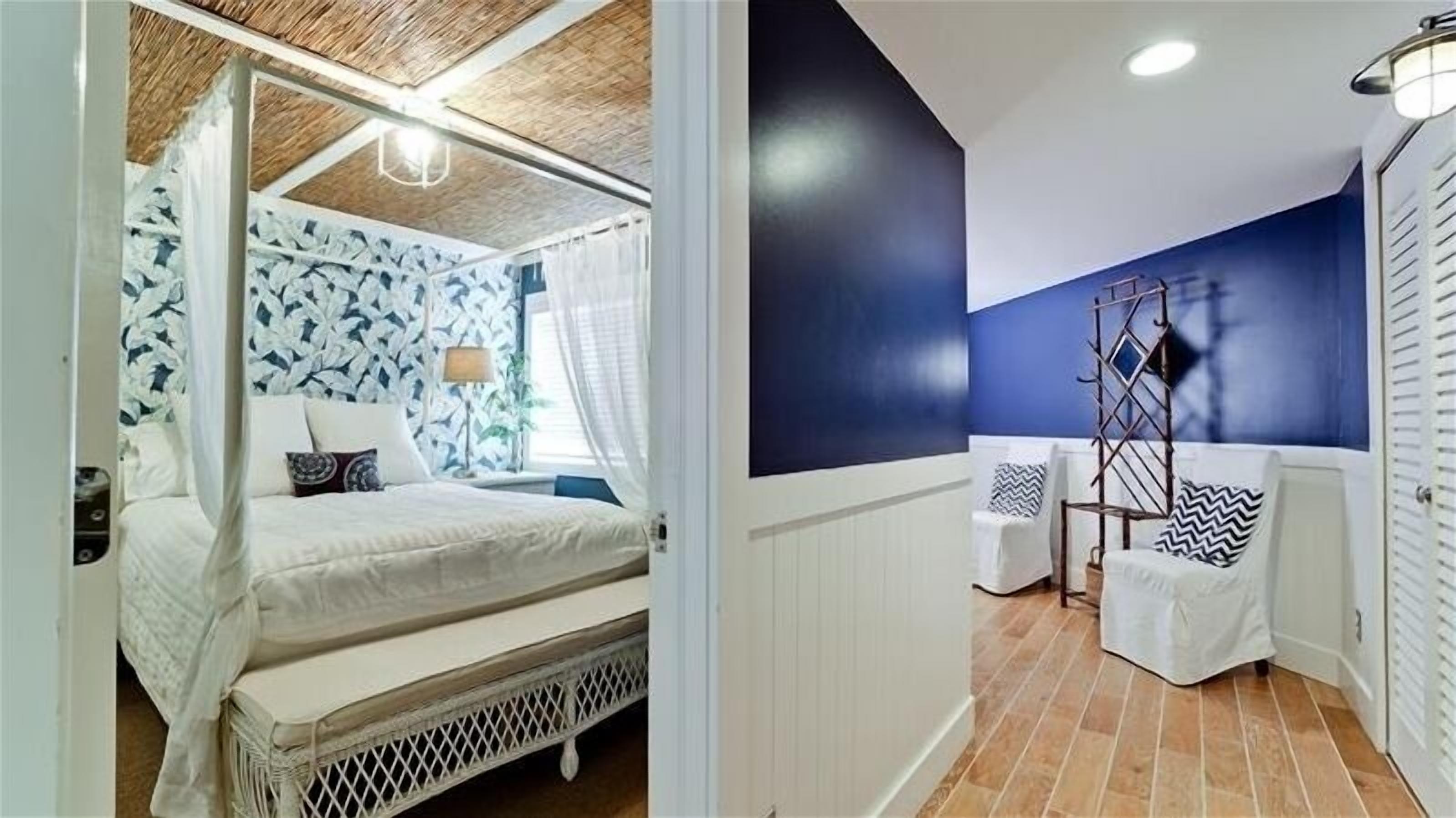 Un dormitorio con cama a dosel, mesita de noche y lámpara.