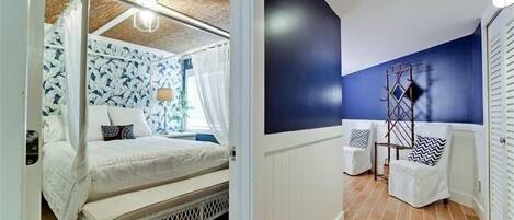 Un dormitorio con cama a dosel, mesita de noche y lámpara.