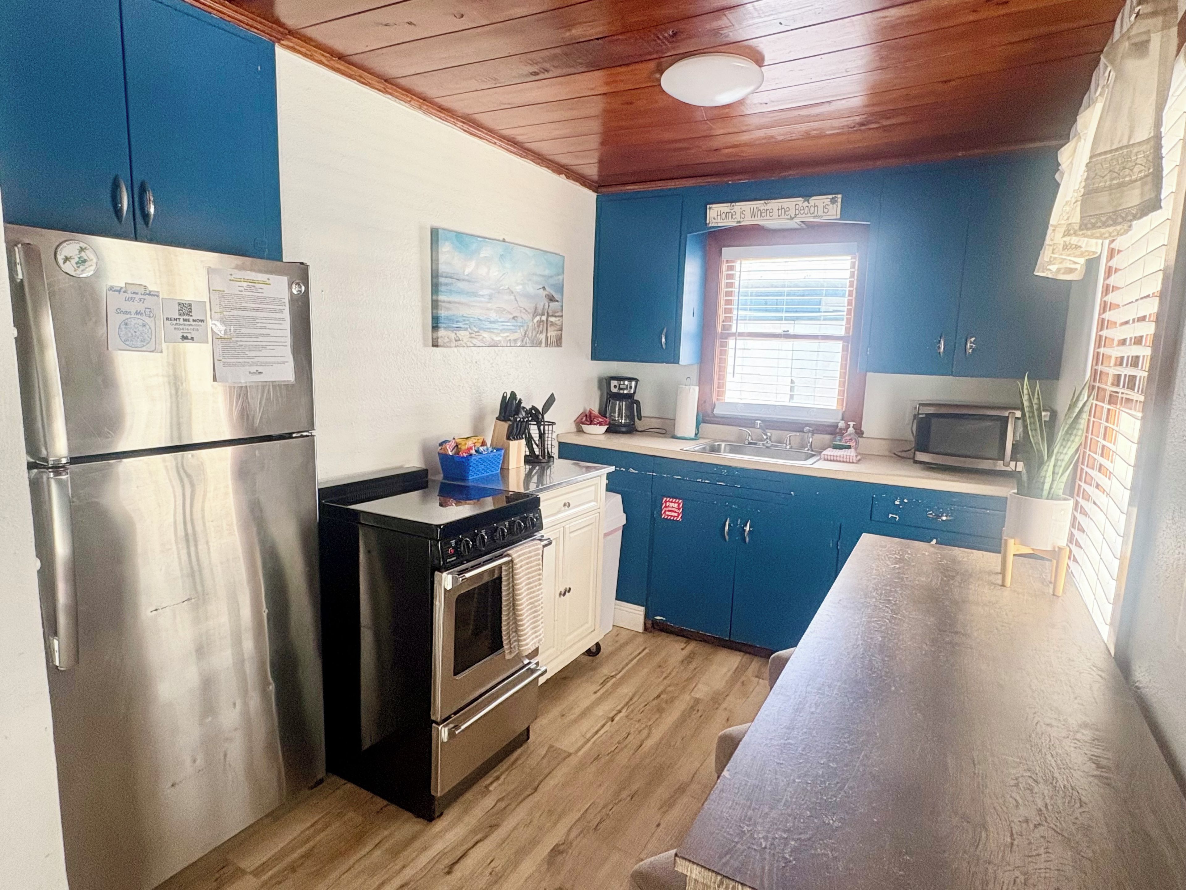A compact kitchen with a refrigerator, stove, and microwave.
