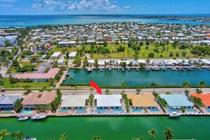 A marina with multiple boats docked, a large body of water, and a residential area with houses and greenery. - P22 - Lovely 3 bedroom 2 bath duplex with private pool, dockage and Cabana Club (Key Colony Beach)