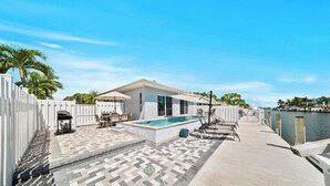 A pool area with a patio, lounge chairs, and a view of the water. - P22 - Lovely 3 bedroom 2 bath duplex with private pool, dockage and Cabana Club (Key Colony Beach)