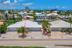 A coastal residential area with houses, a clear sky, and a view of the ocean.