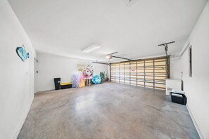 A spacious garage with a concrete floor, a garage door, and a ceiling fan. - P22 - Lovely 3 bedroom 2 bath duplex with private pool, dockage and Cabana Club (Key Colony Beach)