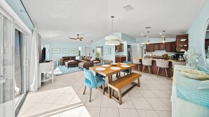 A spacious living area with a dining table, sofas, and a kitchen in the background. - P22 - Lovely 3 bedroom 2 bath duplex with private pool, dockage and Cabana Club (Key Colony Beach)