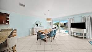 A modern living room with a dining area, a TV, and a view of a pool. - P22 - Lovely 3 bedroom 2 bath duplex with private pool, dockage and Cabana Club (Key Colony Beach)