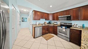 A kitchen with wooden cabinets, stainless steel appliances, and a granite countertop. - P22 - Lovely 3 bedroom 2 bath duplex with private pool, dockage and Cabana Club (Key Colony Beach)
