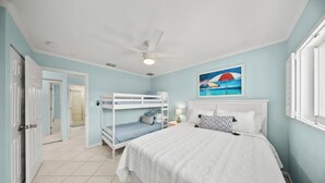 A bedroom with bunk beds, a ceiling fan, and a painting of a beach scene. - P22 - Lovely 3 bedroom 2 bath duplex with private pool, dockage and Cabana Club (Key Colony Beach)